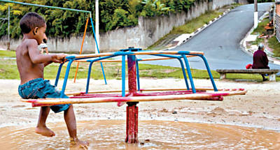 Criança brinca em meio à lama em parque linear de Parelheiros (zona sul de SP), entre as ruas Terezinha do Prado Oliveira e José Pedro de Borba