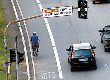 Na guerra por espaço no trânsito paulistano, ciclista trafega em faixa exclusiva para motocicletas na avenida Sumaré