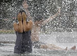 Menina se refresca em fonte de água de Moscou, na Rússia, durante a onda de calor que atingiu o país em julho de 2010