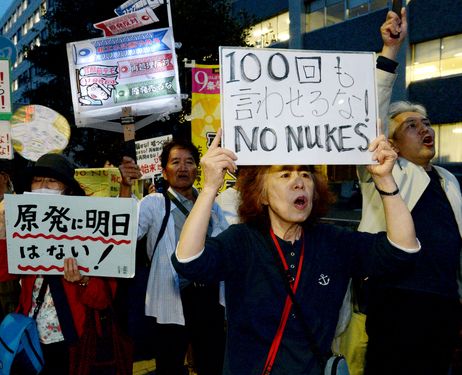 Keiko Kato, a regular participant in Friday night anti-nuclear protests in Tokyo, holds a sign reading “Don’t make us say this 100 times” on May 2. It was the 100th such protest in front of the prime minister’s office in Tokyo’s Chiyoda Ward. (Satoru Ogawa)    