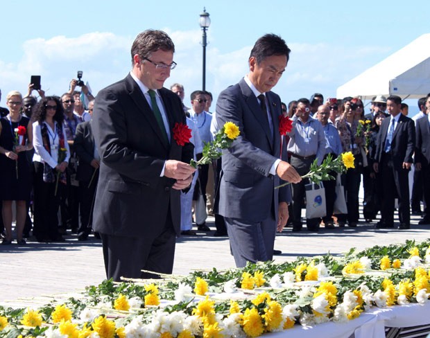  Ministro do Meio Ambiente do Japão Nobuteru Ishihara (dir.) e Achim Steiner (esq.), diretor executivo do Programa de Meio Ambiente das Nações Unidas (Unep) depositam flores no monumento pelas centenas de vítimas de envenenamento por mercúrio na cidade de Minamata; local sediou pior episódio de intoxicação industrial do país. (Foto: AFP Photo/Jiji Press)