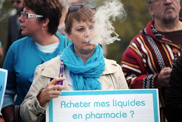 Uma mulher usa um cigarro eletrônico em frente ao Parlamento Europeu, em Estrasburgo, na França, onde usuários e fabricantes do cigarro eletrônico fizeram uma manifestação.  (Foto: AFP Photo/Frederick Florin)