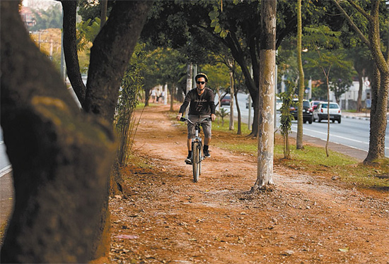 O ciclista Carlos Garcia Magalhães pedala no canteiro central da avenida Sumaré