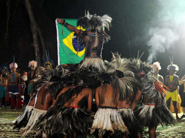 Índios Terena dançam em volta da bandeira do Brasil durante a abertura dos Jogos Verdes Indígenas na aldeia Kari-Oca, montada para a Rio+20  Foto: Antonio Scorza/AFP