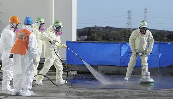 Funcionários tentam descontaminar telhado de prédio próximo a usina de Fukushima, no Japão