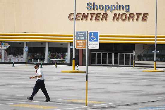 Segurança caminha pelo estacionamento vazio do shopping Center Norte; reabertura ocorre nesta sexta