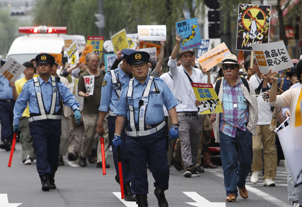 Pessoas fazem protesto em frente à sede da Tokyo Electric Power Co. (Tepco) neste domingo (26) em Tóquio (Foto: AP)