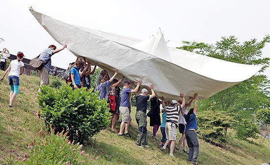 Grupo carrega barco feito com embalagens tetra pak para colocá-lo no canal de Karl-Heine, na cidade de Leipzig