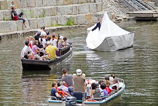 Artista conceitual Frank Boelter flutua com seu barco produzido com material reciclável em canal alemão